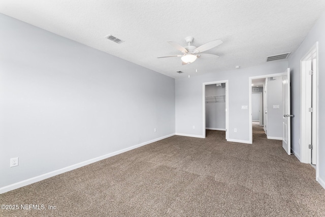 10318 Benson Lake Dr, Jacksonville, FL 32222 - unfurnished bedroom with dark colored carpet, baseboards, a walk in closet, a closet, and a textured ceiling