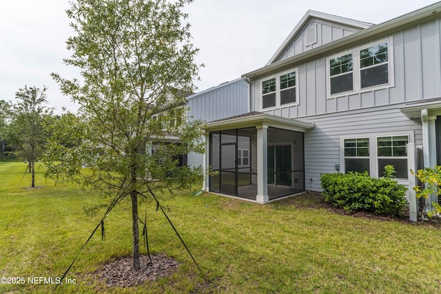 10318 Benson Lake Dr, Jacksonville, FL 32222 - rear view of property featuring board and batten siding, a sunroom, and a lawn