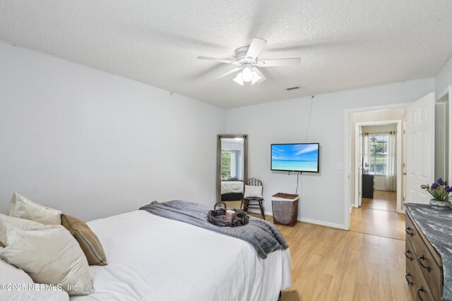 400 Harvest Bend Dr, Fleming Island, FL 32003 - bedroom with light wood-type flooring, a textured ceiling, a ceiling fan, and baseboards