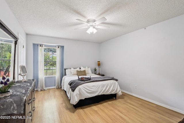400 Harvest Bend Dr, Fleming Island, FL 32003 - bedroom featuring light wood finished floors, baseboards, a ceiling fan, and a textured ceiling