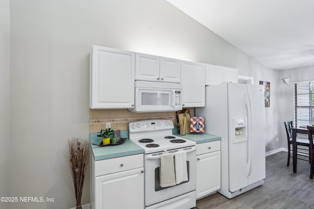 400 Harvest Bend Dr, Fleming Island, FL 32003 - kitchen featuring white appliances, backsplash, white cabinets, light countertops, and vaulted ceiling