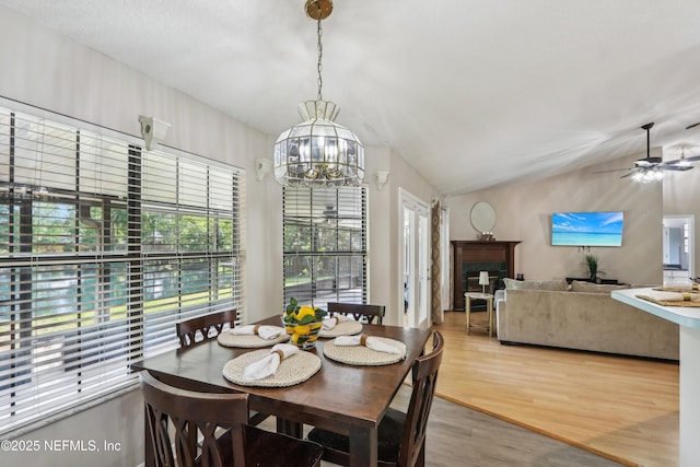 400 Harvest Bend Dr, Fleming Island, FL 32003 - dining space featuring a chandelier, lofted ceiling, light wood finished floors, ceiling fan, and a fireplace