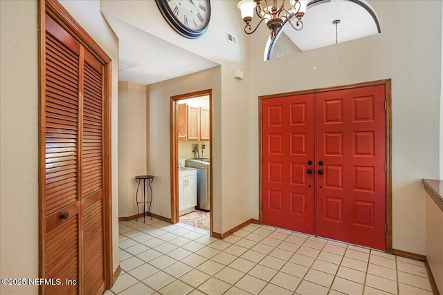 5088 Merrifield Ct, Spring Hill, FL 34608 - foyer with visible vents, a towering ceiling, light tile patterned floors, baseboards, and a chandelier