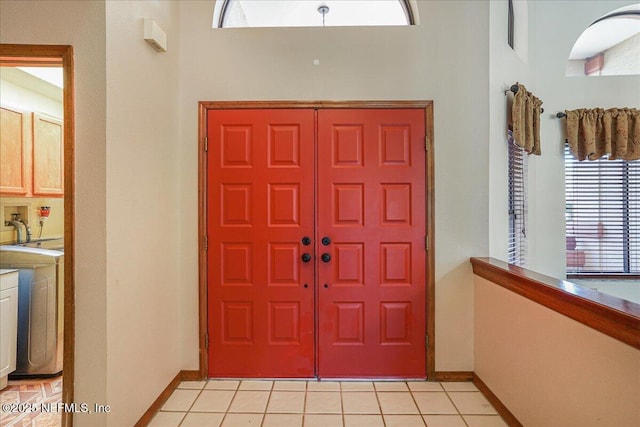5088 Merrifield Ct, Spring Hill, FL 34608 - entryway with baseboards, washer / dryer, and light tile patterned flooring