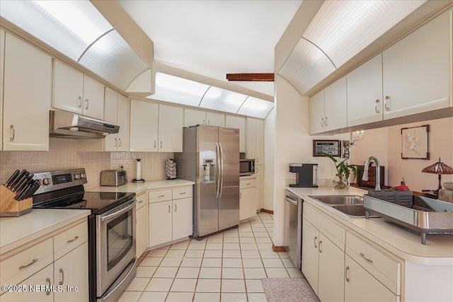 5088 Merrifield Ct, Spring Hill, FL 34608 - kitchen with decorative backsplash, light tile patterned flooring, under cabinet range hood, a sink, and stainless steel appliances