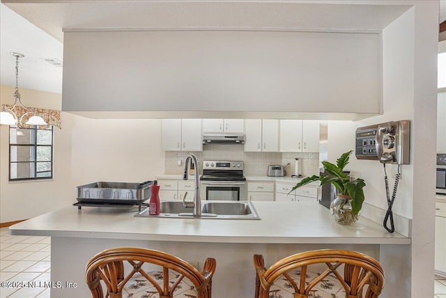 5088 Merrifield Ct, Spring Hill, FL 34608 - kitchen featuring stainless steel electric range oven, a sink, light countertops, decorative backsplash, and under cabinet range hood