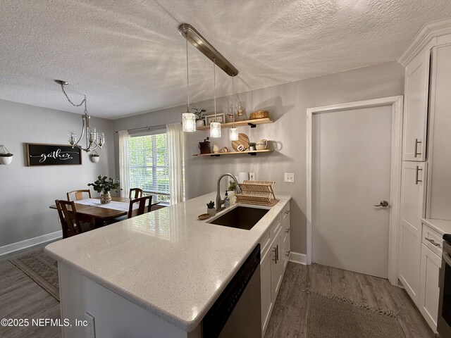 2599 Sandy Hollow Dr, Middleburg, FL 32068 - kitchen with dishwasher, wood finished floors, a textured ceiling, a peninsula, and white cabinets