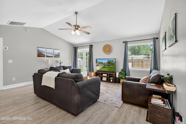 2599 Sandy Hollow Dr, Middleburg, FL 32068 - living room with light wood-style flooring, ceiling fan, vaulted ceiling, and a textured ceiling