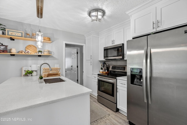 2599 Sandy Hollow Dr, Middleburg, FL 32068 - kitchen featuring stainless steel appliances, white cabinets, open shelves, light wood-type flooring, and light stone countertops