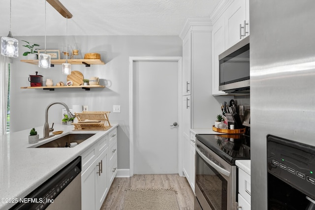 2599 Sandy Hollow Dr, Middleburg, FL 32068 - kitchen featuring appliances with stainless steel finishes, light wood-style flooring, light countertops, open shelves, and white cabinetry