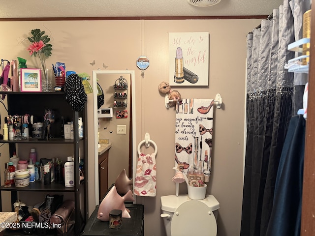 bathroom featuring toilet, curtained shower, and visible vents