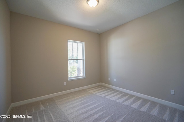 unfurnished room with baseboards and carpet flooring