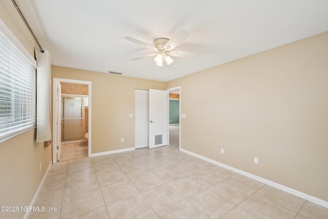 369 Altara Dr, Saint Augustine, FL 32086 - unfurnished bedroom with baseboards, light tile patterned floors, ensuite bathroom, and ceiling fan