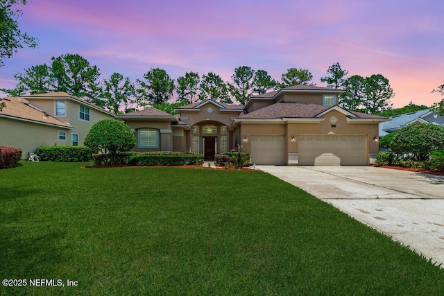 mediterranean / spanish-style house with stucco siding, an attached garage, a front lawn, and concrete driveway