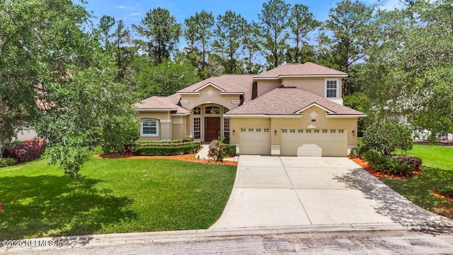 mediterranean / spanish home with a garage, stucco siding, concrete driveway, and a front yard