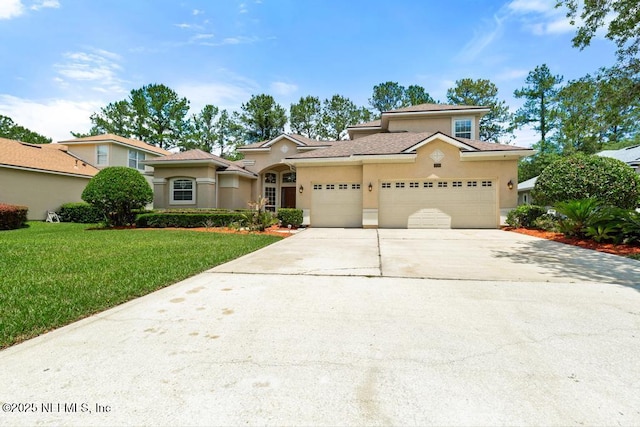 view of front of home with stucco siding, a front yard, concrete driveway, and a garage