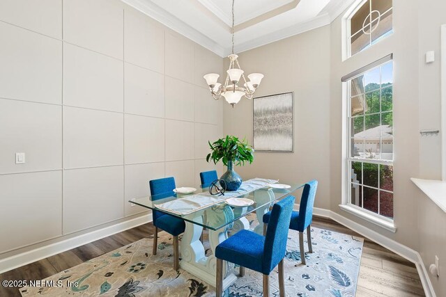 dining room with crown molding, a chandelier, wood finished floors, and baseboards