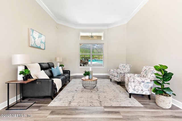 living room featuring crown molding, baseboards, wood finished floors, and ceiling fan