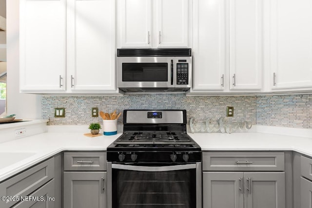 kitchen featuring stainless steel appliances, gray cabinetry, tasteful backsplash, and light countertops