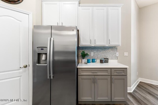 kitchen with stainless steel fridge with ice dispenser, gray cabinets, backsplash, light countertops, and baseboards