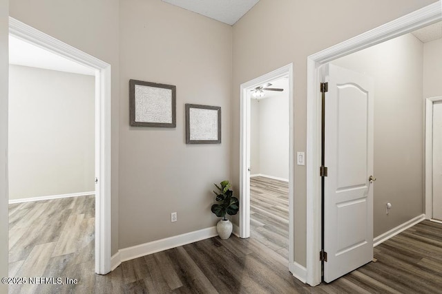 corridor featuring wood finished floors and baseboards