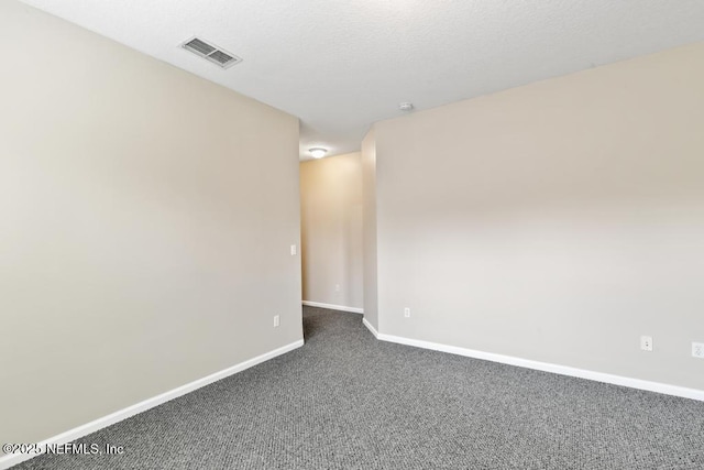 empty room with dark carpet and baseboards