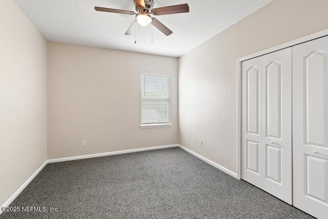 unfurnished bedroom featuring carpet, baseboards, a closet, a textured ceiling, and ceiling fan