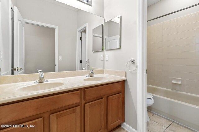 full bath with tile patterned floors, double vanity, toilet, and washtub / shower combination