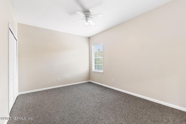 carpeted spare room featuring a ceiling fan and baseboards