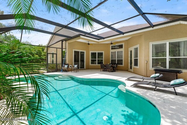 outdoor pool featuring ceiling fan, a patio area, a lanai, and a jacuzzi