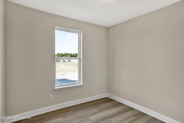 unfurnished room with baseboards and wood finished floors