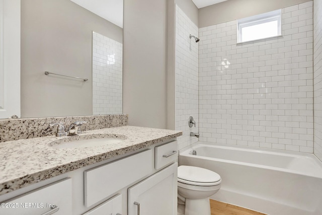 bathroom with toilet, washtub / shower combination, wood finished floors, and vanity
