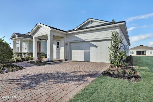 single story home with an attached garage, decorative driveway, and a front yard