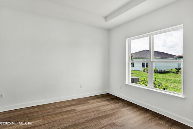 unfurnished room featuring baseboards, plenty of natural light, and dark wood-type flooring