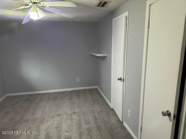 unfurnished room with baseboards, ceiling fan, carpet, and visible vents