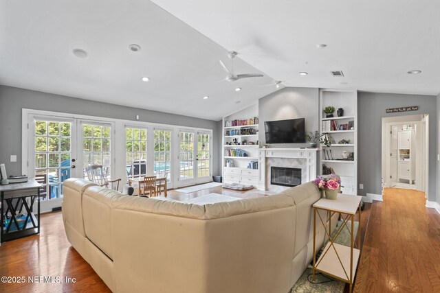 11136 River Creek Dr W, Jacksonville, FL 32223 - living room featuring french doors, ceiling fan, vaulted ceiling, wood finished floors, and a high end fireplace