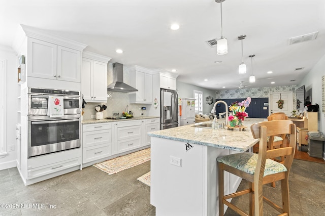 11136 River Creek Dr W, Jacksonville, FL 32223 - kitchen with wall chimney exhaust hood, appliances with stainless steel finishes, a sink, white cabinets, and recessed lighting