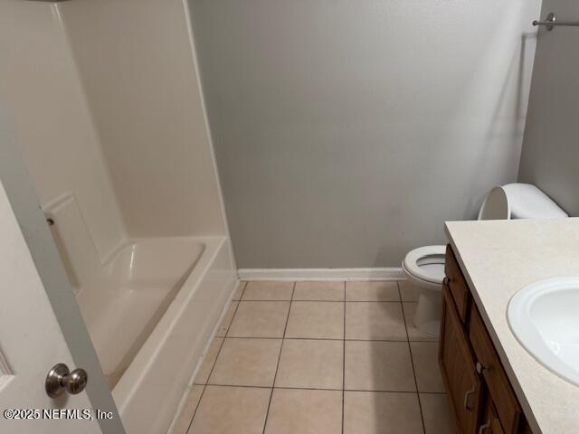 bathroom featuring toilet, baseboards, tile patterned flooring, and vanity