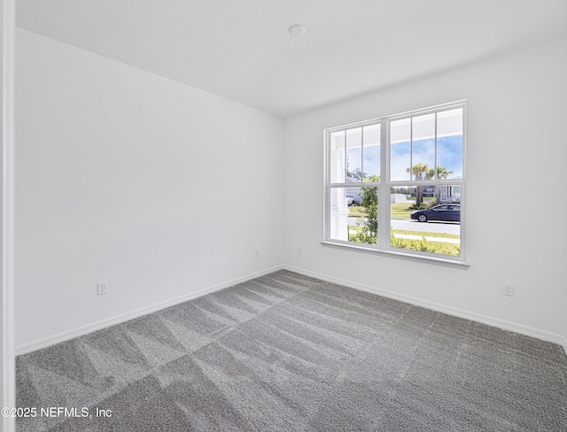 empty room with baseboards and carpet floors