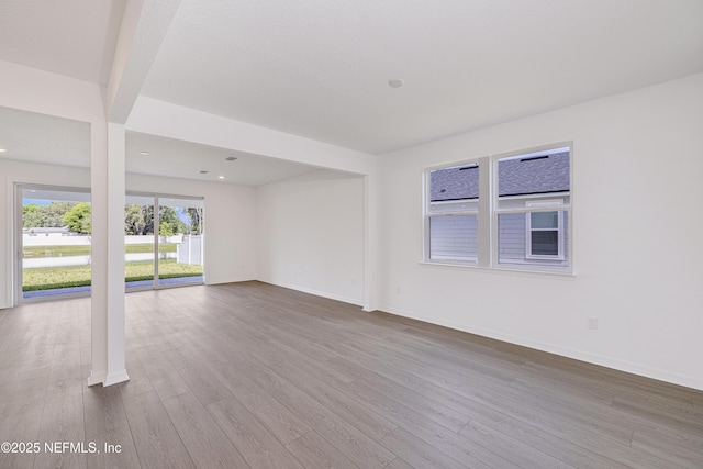 unfurnished living room featuring dark wood-style flooring, baseboards, and recessed lighting