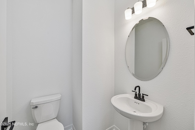half bath with a sink and toilet