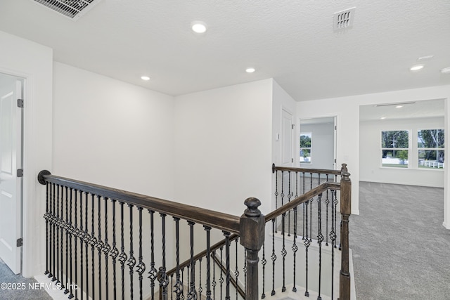 hallway with visible vents, carpet, recessed lighting, and an upstairs landing