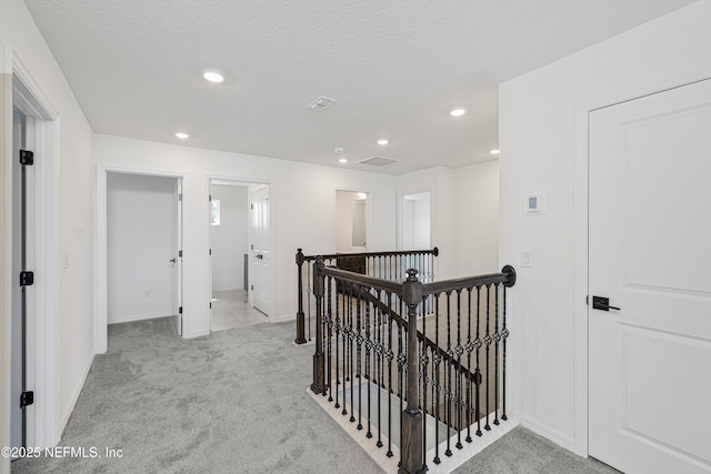 hallway featuring baseboards, carpet flooring, recessed lighting, and an upstairs landing