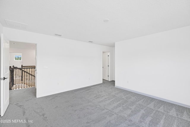 carpeted spare room featuring baseboards and visible vents