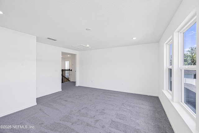 carpeted spare room with recessed lighting, a textured ceiling, visible vents, and baseboards