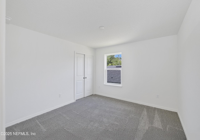 unfurnished room featuring baseboards and carpet