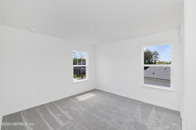spare room with baseboards and carpet