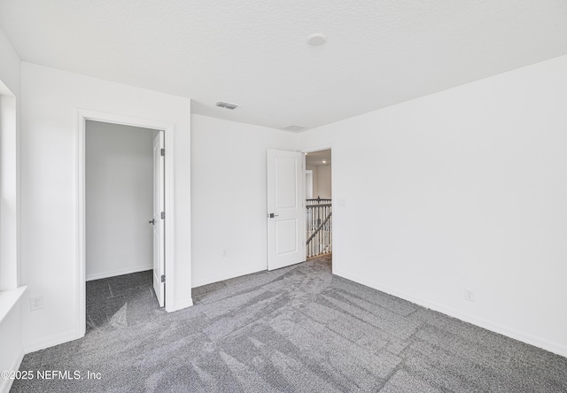 unfurnished bedroom featuring carpet floors, baseboards, and visible vents
