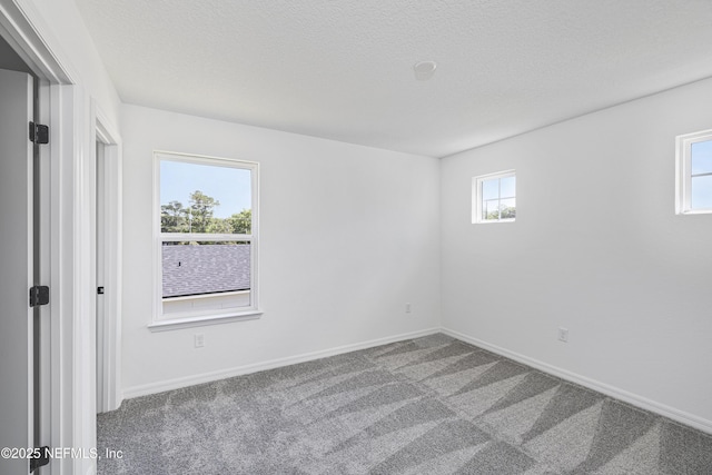 unfurnished bedroom featuring a textured ceiling, baseboards, and carpet