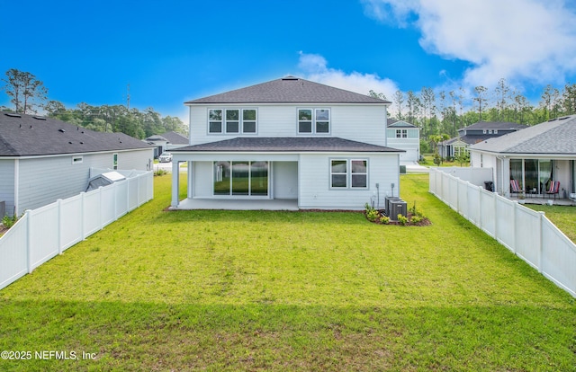 rear view of house featuring a lawn, a patio, cooling unit, and a fenced backyard